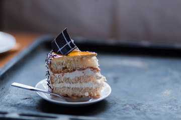 piece of cake on a white saucer on a black background copyspace