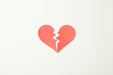 Red paper broken heart on white background
