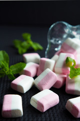 colorful marshmallow, candy and mint in glass bowls close-up on a dark background