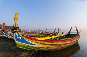 traditional boat at sunrise in Taungthaman Lake near the U Bein Bridge, Mandalay, Myanmar , selective focus, color tone effect.