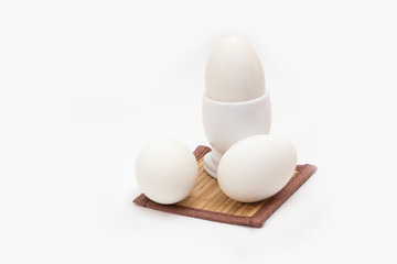 three eggs in the stand on a white background