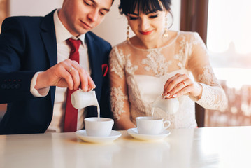 Groom and bride relaxing together in cafe