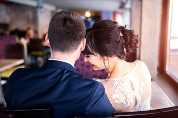 Young wedding couple relaxing together in cafe
