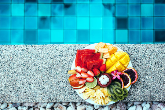 Relaxing with fruits by the pool