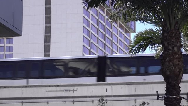 Monorail goes by in city on rail.
