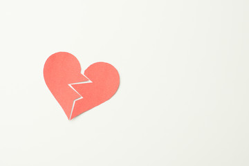 Red paper broken heart on white background