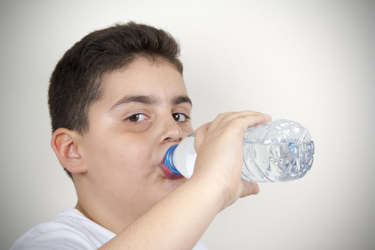 Boy Is Drinking Water From The Bottle 