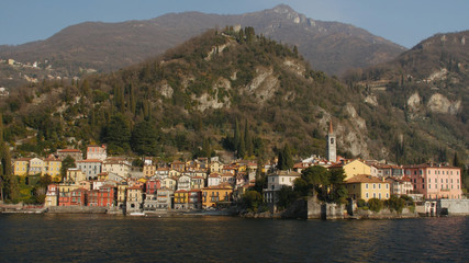 The beautiful shores of Lake Como with the town of Varenna and the Italian Alps in background. View from ferry.