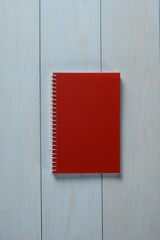 Libreta de color rojo sobre fondo de madera azul