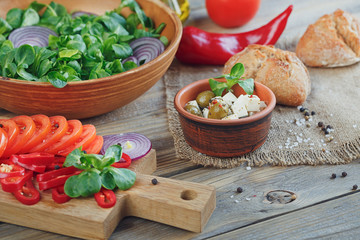 Ingredients for vegetables salad on a wooden background.
