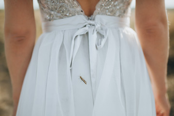 grasshopper sits on a bride's wedding dress