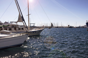 View of Yachts (sailing boats) parked at Yalikavak marina. Lens flare effects applied image.