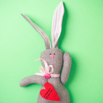 Easter bunny on a green background. Rabbit. Easter ideas. Easter eggs. Space for text. Black lettering on a heart happy easter.