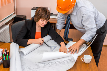 Project Manager and engineer discussing building plans in the office