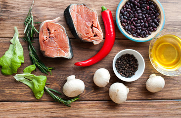 Sea fish and vegetables, ingredients for cooking seafood. Banner for a restaurant, top view on a wooden background.
