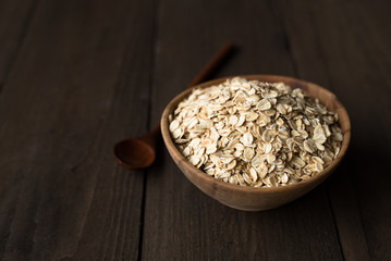Oat flakes in old wooden bowl