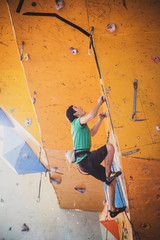 man climbs a route in a training room, competition