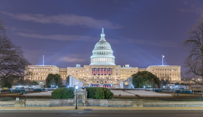 The West side of the US Capitol Building as it is prepared for the 58th presidential inauguration ceremony. The platform has been created and four of the five flags have been hung.