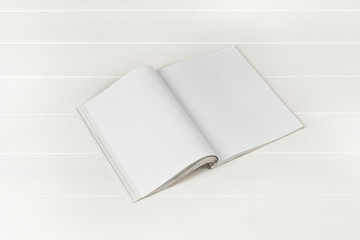 Mock-up magazine or catalog on white wooden table. Blank page or notepad on wood background. Blank page or notepad for mockups or simulations.