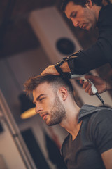 Handsome man at the hairdresser getting a new haircut