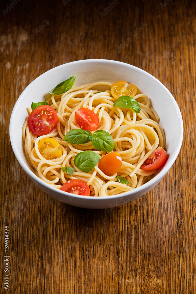 Wall mural Delicious pasta in bowl on wooden background 