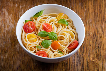 Delicious pasta in bowl on wooden background 