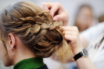 Young woman getting her hair done before party