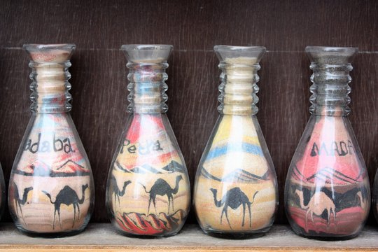 Traditional souvenirs in bottles with sand, desert and camels, Petra in Jordan