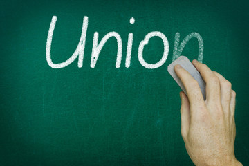 Hand erasing the word UNION written on blackboard