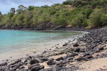 Fototapeta na wymiar Beautiful beach with volcanic rocks and clear water in Sao Tome and Principe Island, in Africa