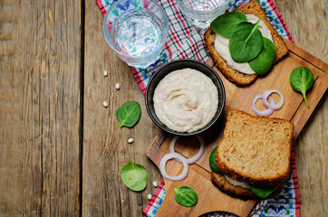 White bean hummus spinach rye sandwich