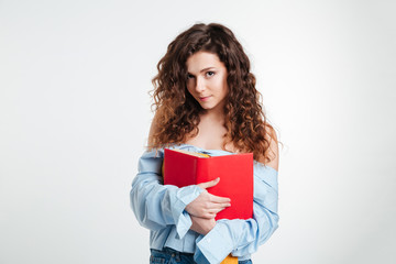 Portrait of a cute young woman holding book