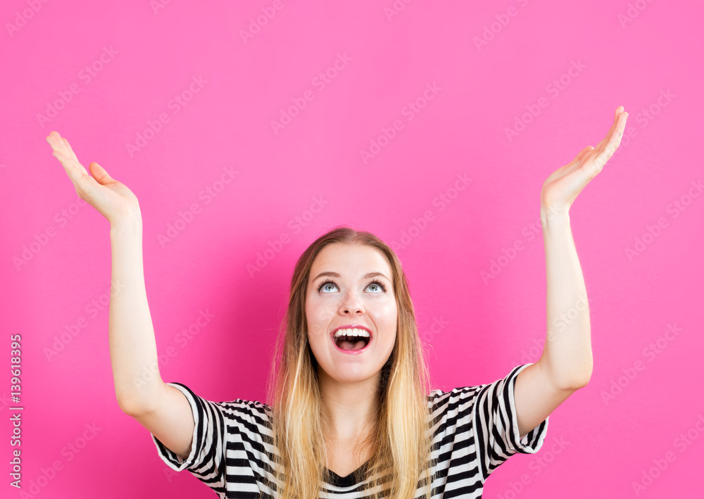 Wall mural young woman reaching and looking upwards