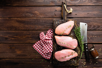 Raw chicken meat fillet on wooden background top view