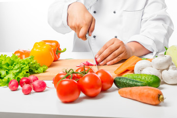 hand cook cut vegetables for salad close up on a wooden board