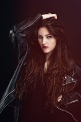 Portrait d'une jeune femme sensuelle portant un blouson en cuir, le regard vers l'objectif