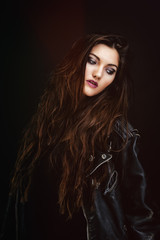 Portrait d'une jeune femme sensuelle portant un blouson en cuir, le regard sur le coté