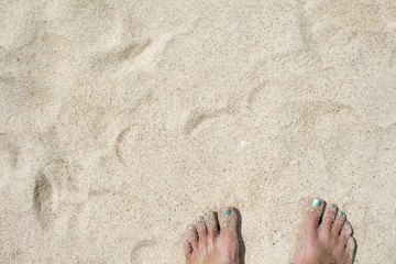 Female feet on white sand. Coral beach by the tropical seaside