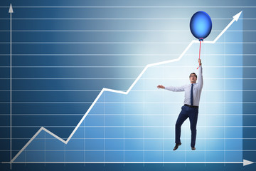 Businessman flying on hot balloon over graph