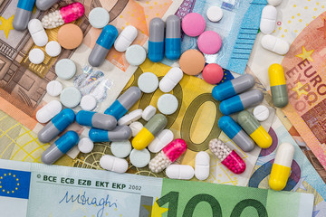 different pills above euros bills. close up.
