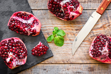 sliced pomegranate on wooden background top view