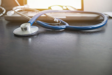 Stethoscope,a medical instrument for listening to action of heart or breathing lay on laptop keyboard in doctor office,Medical concept ,relax time doctor,selective focus,vintage color.copy space
