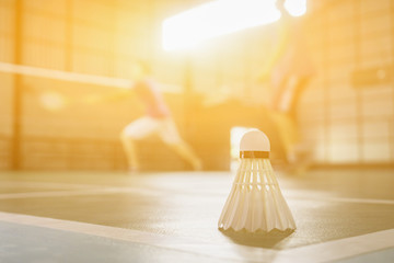 A set of badminton concept.Badminton ball (shuttlecock) and racket on court floor,Paddle ,the shuttlecock and badminton courts with players competing in modern gym,selective focus,vintage color