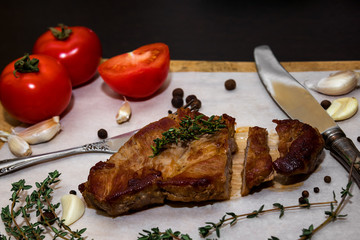 Juicy beef steak on a wooden old cutting board with spices and vegetables. On a black background for text design for restaurant menus. Food background.