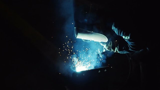 Welding work at construction site in dark in slow motion