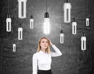 Woman scratching head and light bulbs