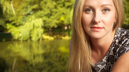 Naklejka premium Woman sitting in park, relaxing and using phone