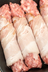 Homemade kebabs rolled in bacon on the wooden board