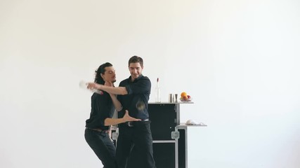 Professinal bartender men juggling bottles and shaking cocktail at mobile bar table on white background studio indoors