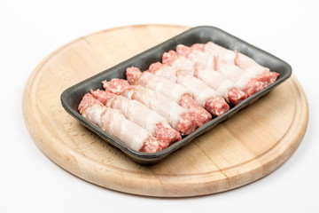 Homemade kebabs rolled in bacon on the wooden board